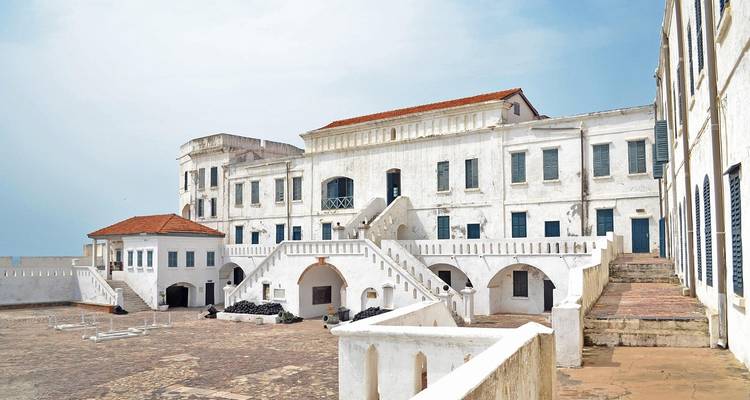 Château historique en pierre blanche avec cours et escaliers.