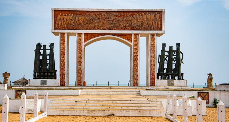 Monument avec sculptures dans un lieu en bord de mer.