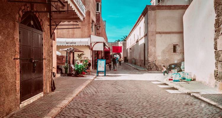 Straßenszene in einem historischen Viertel mit marokkanischer Flagge.