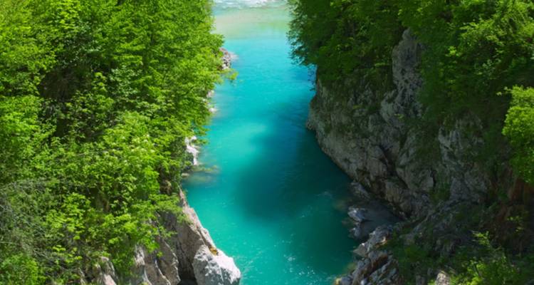 Río turquesa angosto entre acantilados verdes y exuberantes.