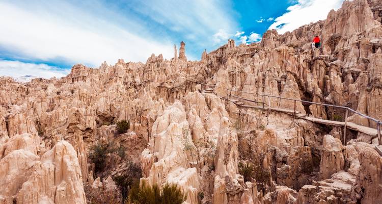 Een persoon die door het ruige terrein van de Maanvallei loopt.