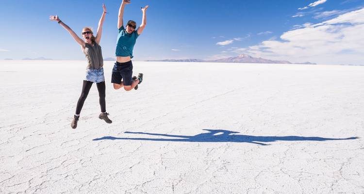Een vrolijk stel dat springt op de uitgestrekte Uyuni-zoutvlaktes.