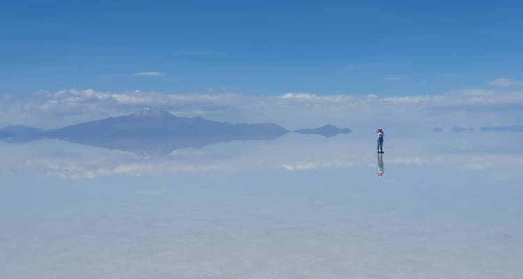 Una persona solitaria en medio de la extensión reflectante de las salinas.