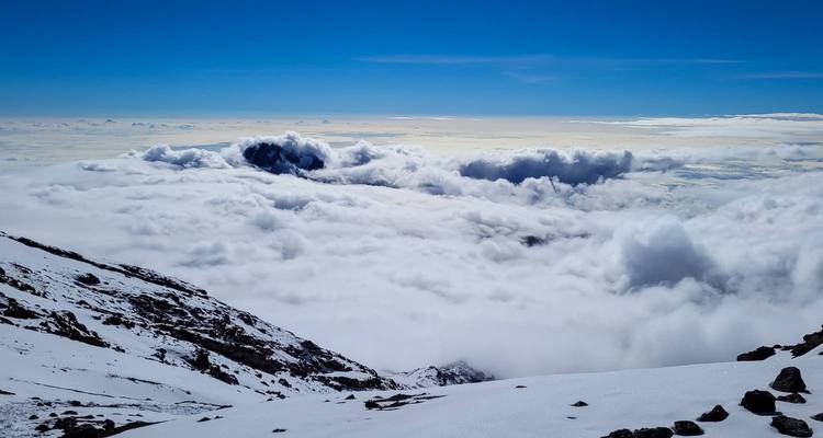 Vaste paysage nuageux depuis un versant de montagne.