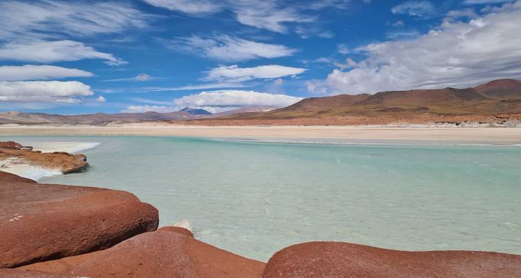 Vue époustouflante d'un lac turquoise entouré de montagnes.