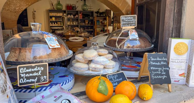Une vitrine de boulangerie avec diverses pâtisseries, des panneaux, et une vue sur un intérieur de magasin accueillant.