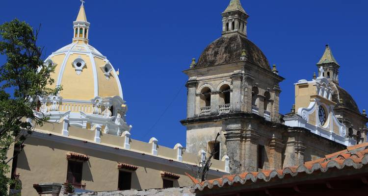 Les dômes et clochers de la cathédrale historique de Carthagène brillent contre un ciel bleu profond.