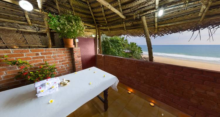 Table de massage sur un balcon avec vue sur une plage.