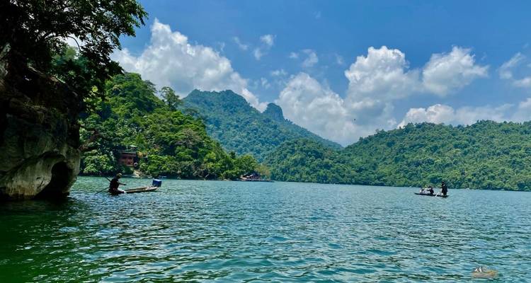 Mensen in boten op een schilderachtig meer omringd door bergen.