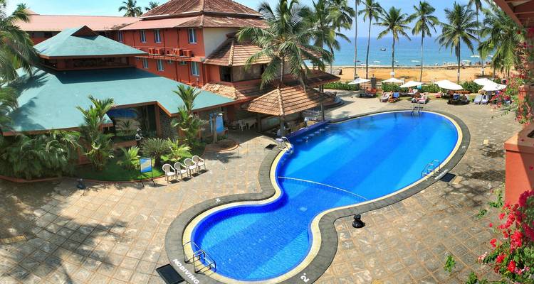 Een resortpoolgebied met palmbomen en uitzicht op de oceaan.