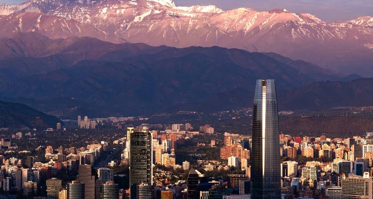 Horizonte urbano con un telón de fondo montañoso bajo colores vibrantes del cielo.