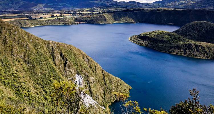 Luftaufnahme eines Sees, umgeben von grünen Klippen.