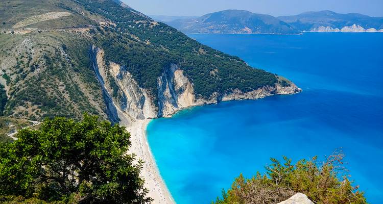 Vista espectacular desde el acantilado de la playa de Myrtos y el mar Jónico de un azul intenso enmarcado por escarpadas laderas verdes en Cefalonia.
