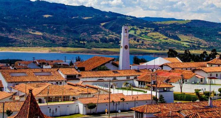 Malerische Stadt mit einem einzigartigen weißen Uhrenturm und Bergen.