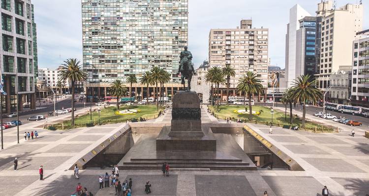 Place de la ville avec un monument élevé et des bâtiments modernes.