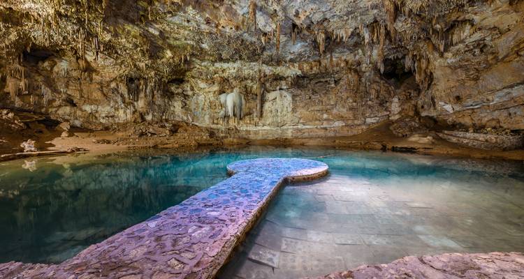 Cenote subterráneo con formaciones y agua.