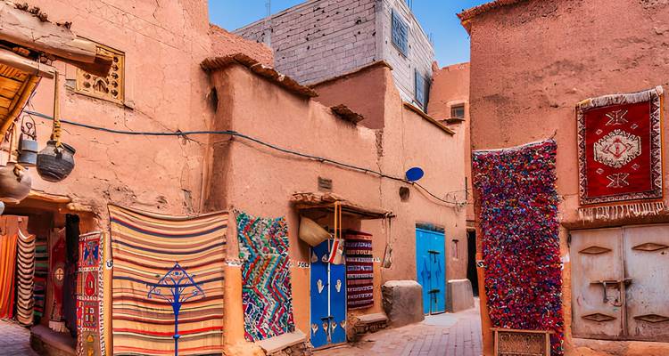 Rue étroite avec des textiles colorés et une architecture traditionnelle.