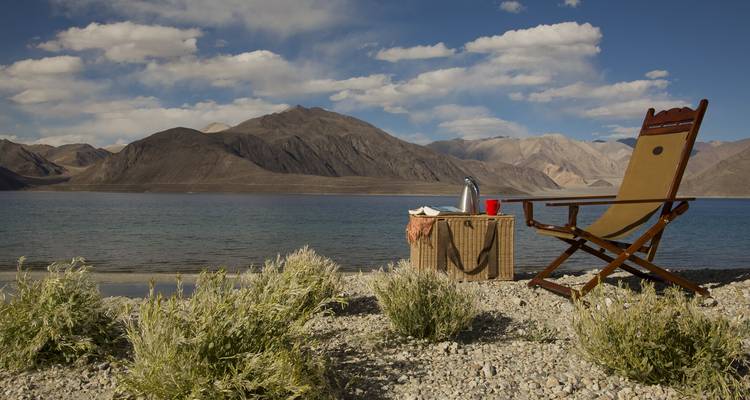 Ensemble chaise et table près du lac Pangong Tso avec montagnes.