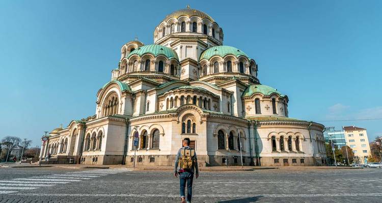 Voyageur debout devant une grande cathédrale.