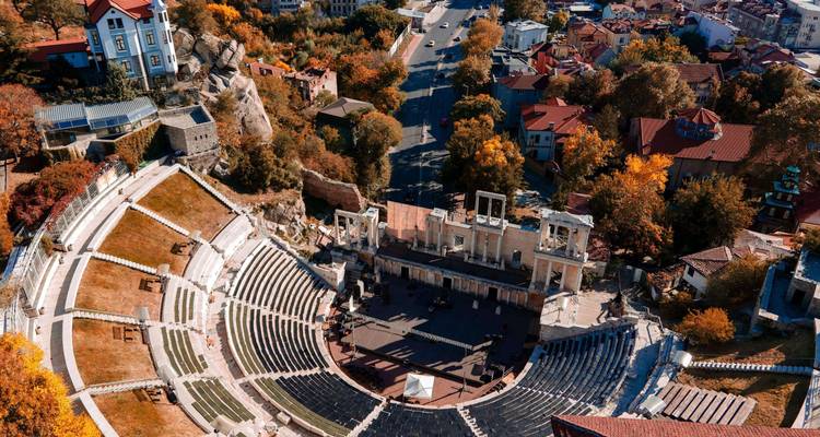 Amphithéâtre romain antique entouré d'arbres d'automne.