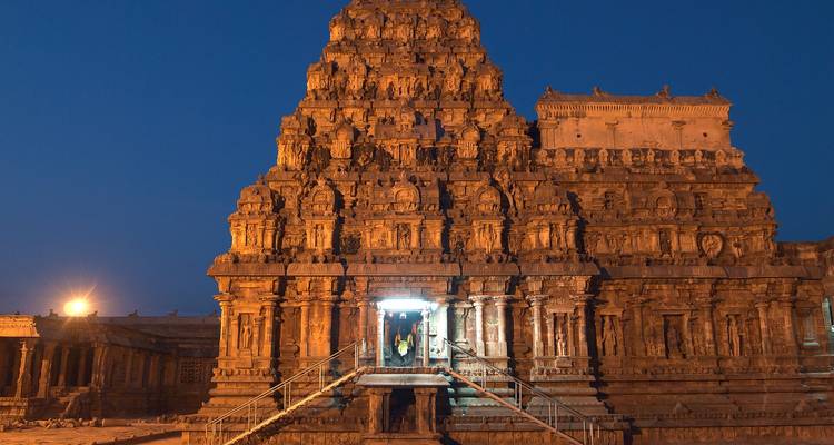 Un ancien temple de pierre illuminé pendant la nuit.