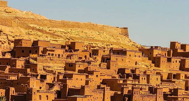 Ein Blick auf die Kasbah-Strukturen von Ait Benhaddou vor einem klaren Himmel.