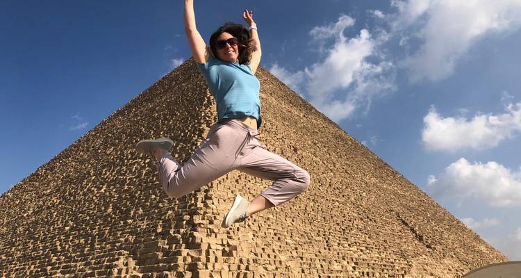 Una mujer saltando frente a la Gran Pirámide de Giza.
