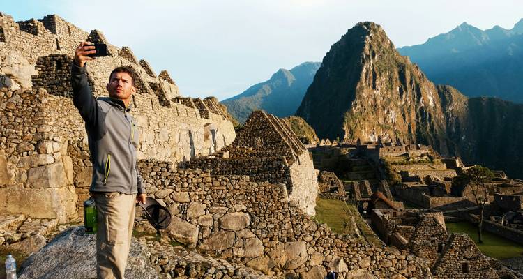 Une personne prenant un selfie avec le Machu Picchu en arrière-plan.
