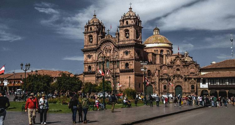 Cathédrale de style baroque à Cusco avec des gens devant.