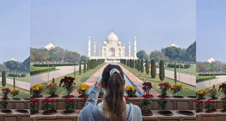 Vista del Taj Mahal con una mujer tomando una foto.
