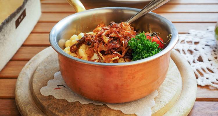 Plat traditionnel servi dans un pot en métal sur une table.
