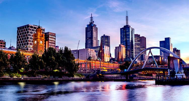 Horizon urbain avec une rivière au premier plan, lumineux pendant le crépuscule.