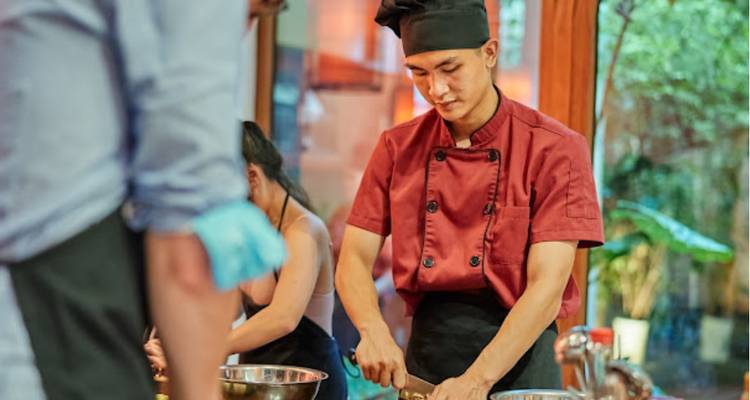 Chef preparando comida en una cocina bien iluminada.