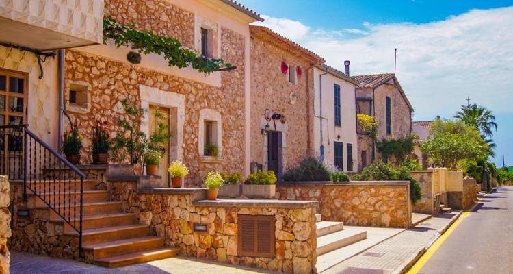 Charmante rue avec des bâtiments en pierre sous un ciel bleu.