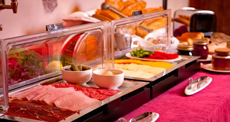 Variété de fromages, de viandes et d'autres articles sur une table de buffet.