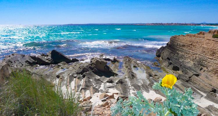 Vue côtière avec des eaux bleues éclatantes et des rivages rocheux.