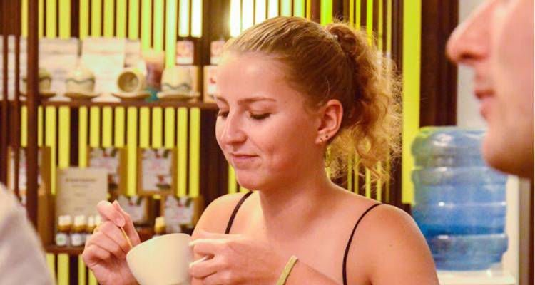 Primer plano de una persona sosteniendo una taza en un ambiente acogedor.