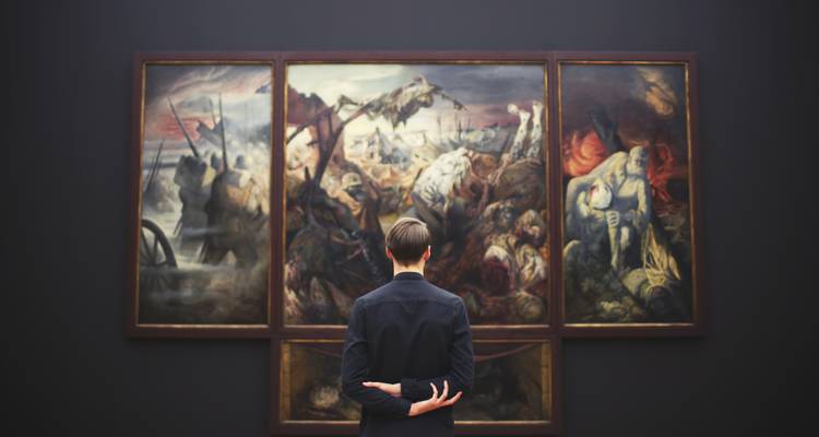 Persona viendo pinturas grandes en una galería de arte.