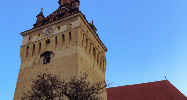 Tour d'horloge sur un bâtiment historique contre un ciel bleu dégagé.