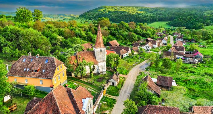 Village pittoresque avec une église et un environnement verdoyant, vu d'en haut.