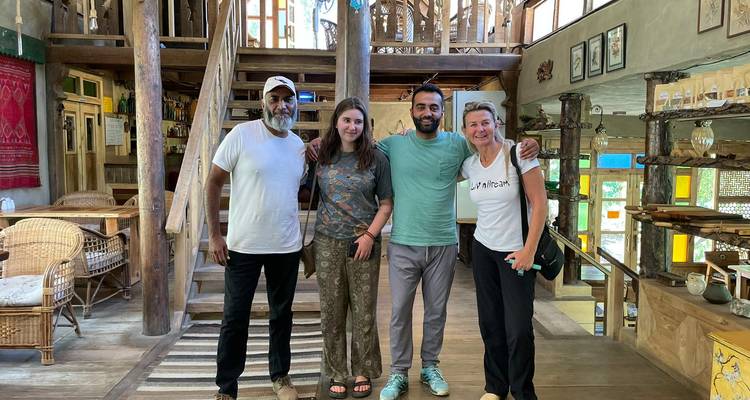 Quatre personnes posant à l'intérieur d'une cabane en bois.