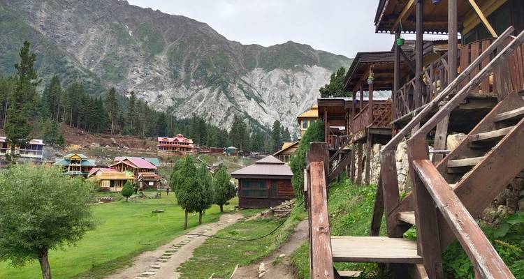 Un village avec des cabanes et un arrière-plan montagneux.