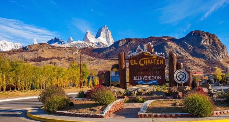 Un panneau de bienvenue à El Chalten avec des montagnes en arrière-plan.