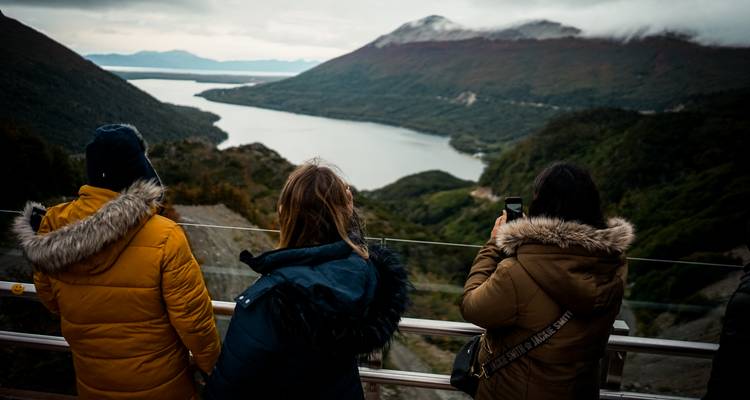 Des gens qui regardent un lac pittoresque et des montagnes.