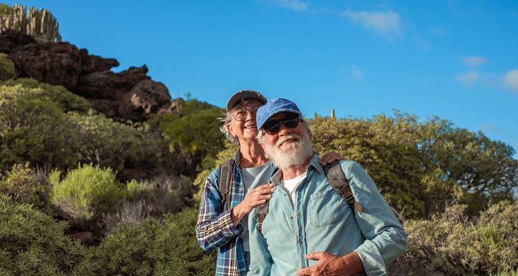 Elderly couple enjoying a hike in the Galapagos terrain.