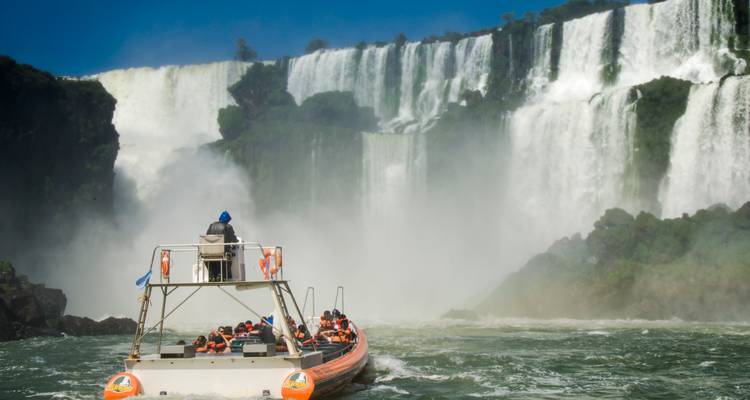 Ein Boot mit Touristen nähert sich den Iguazu-Fällen.