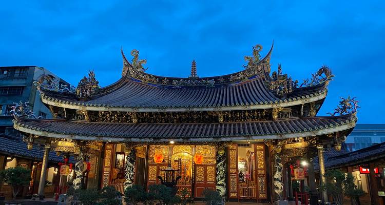 Un temple magnifiquement orné avec des détails dorés complexes sur un ciel bleu profond.