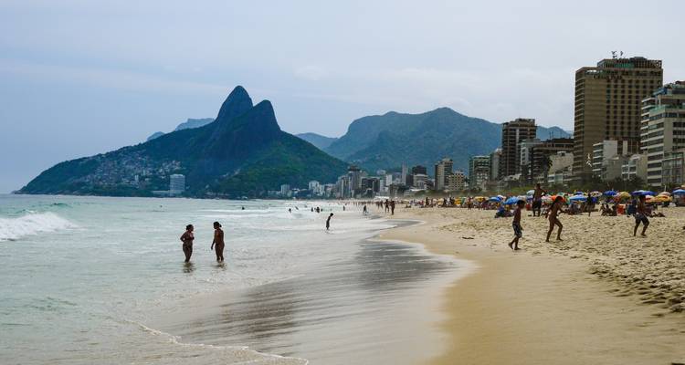Ipanema strand met mensen en verre bergen.