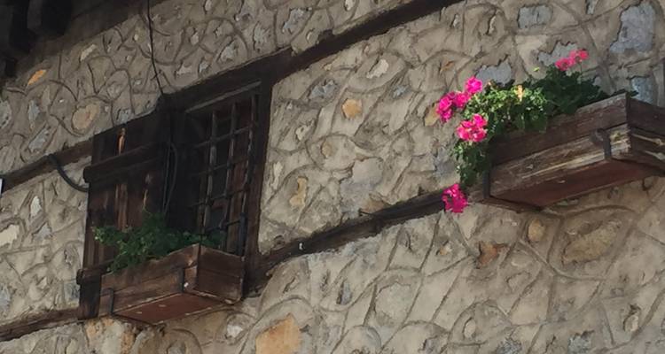 Gros plan d'une façade de bâtiment en pierre avec des jardinières.