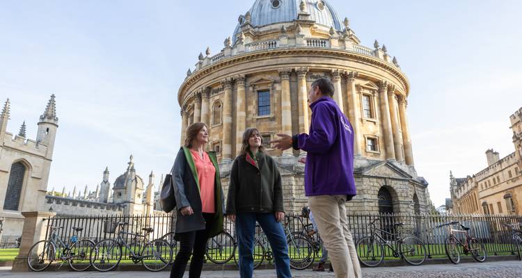 Des touristes debout devant la Radcliffe Camera à Oxford.